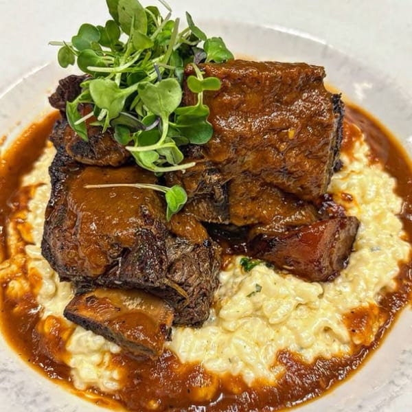 Braised short ribs with a rich brown sauce and microgreens, served over creamy risotto.
